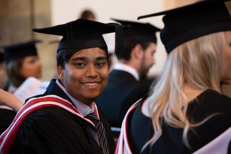 Male student in cap and gown at graduation